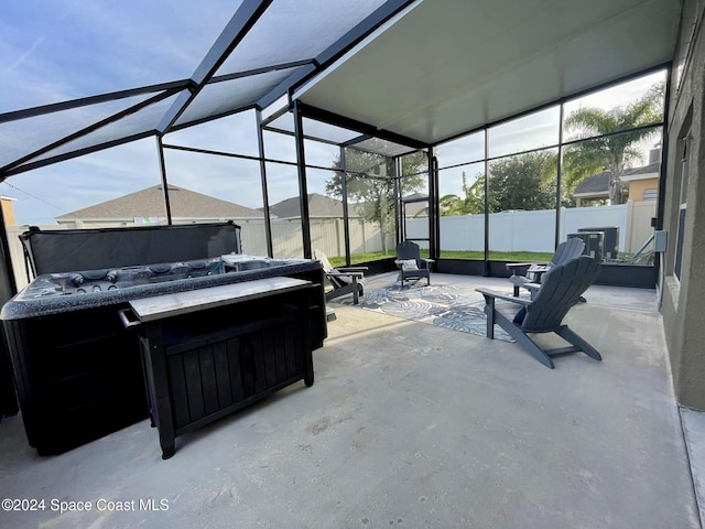 view of patio with glass enclosure, fence, and a jacuzzi