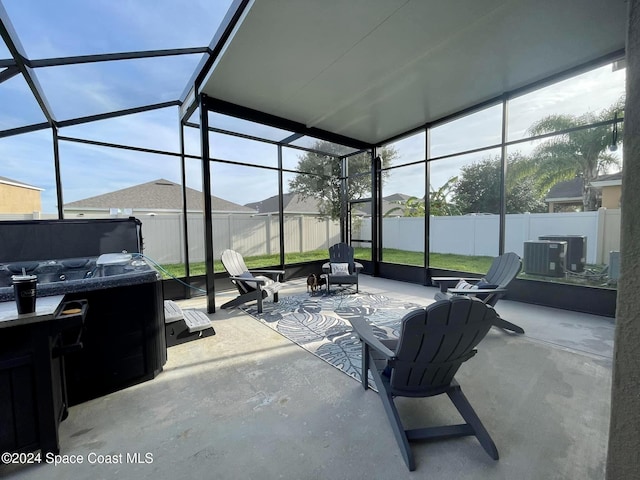 view of patio featuring glass enclosure, a fenced backyard, a hot tub, and central air condition unit