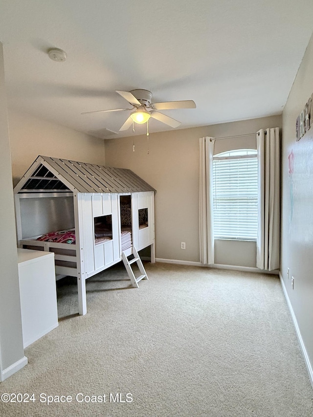 unfurnished bedroom featuring carpet floors, baseboards, and a ceiling fan