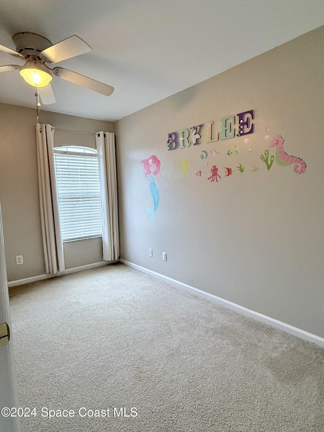 spare room featuring carpet, baseboards, and a ceiling fan