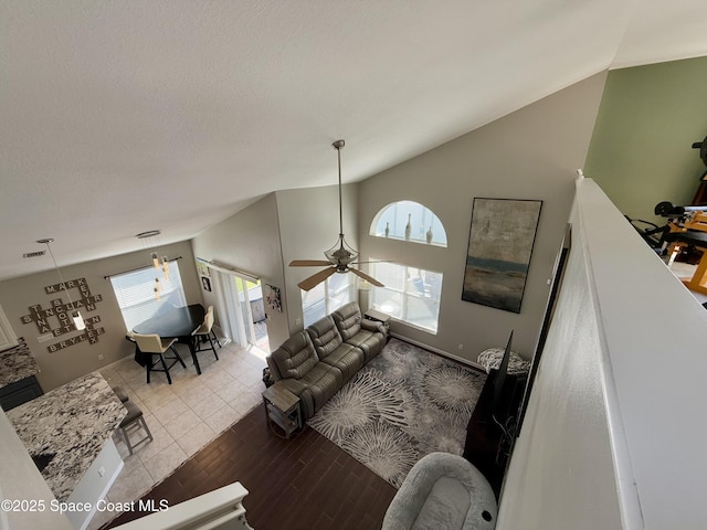 living room featuring visible vents, ceiling fan, wood finished floors, a textured ceiling, and high vaulted ceiling