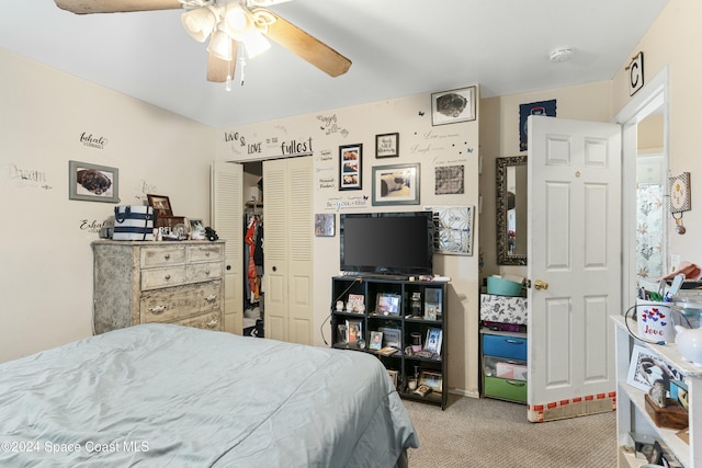 bedroom with ceiling fan, light colored carpet, and a closet