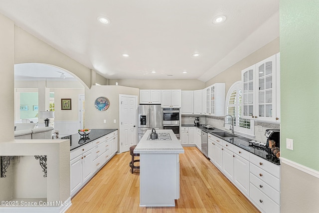 kitchen featuring a center island, white cabinetry, stainless steel appliances, light hardwood / wood-style floors, and sink