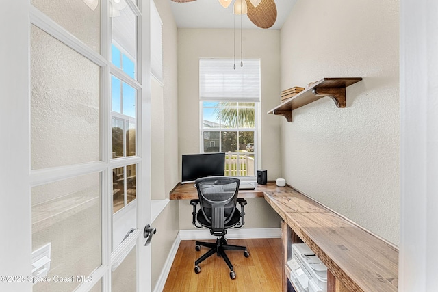 office space featuring ceiling fan, a wealth of natural light, and hardwood / wood-style flooring