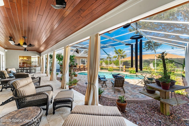 view of patio / terrace featuring ceiling fan and glass enclosure