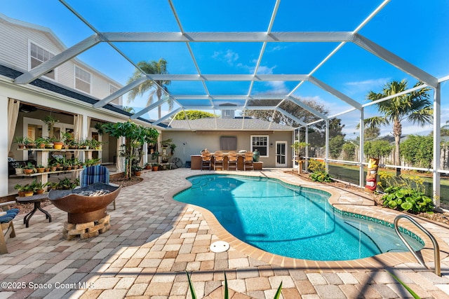 view of pool with a bar, a patio, and glass enclosure