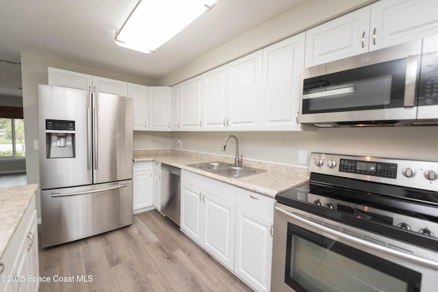 kitchen with appliances with stainless steel finishes, sink, and white cabinetry