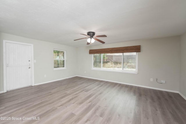 spare room featuring ceiling fan, a wealth of natural light, and wood-type flooring