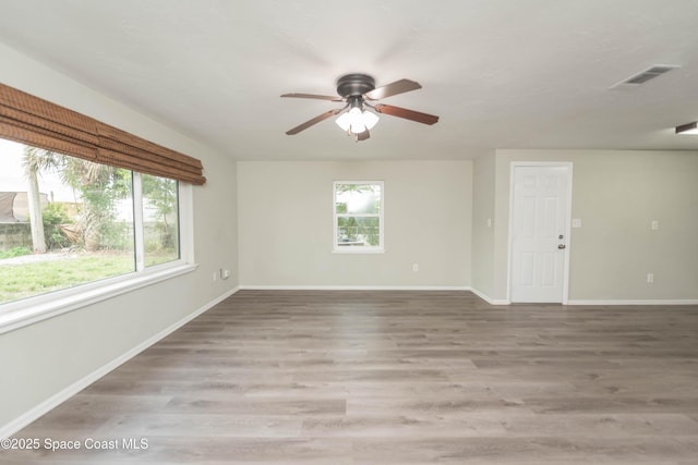 unfurnished room with ceiling fan, a healthy amount of sunlight, and hardwood / wood-style flooring