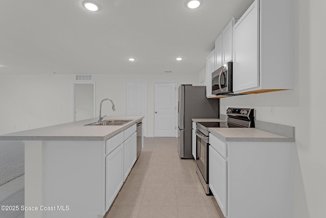 kitchen featuring a center island with sink, sink, white cabinetry, and stainless steel appliances