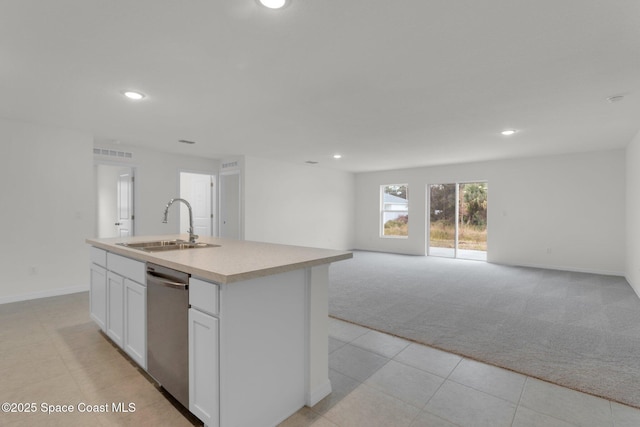 kitchen with sink, stainless steel dishwasher, an island with sink, light colored carpet, and white cabinets