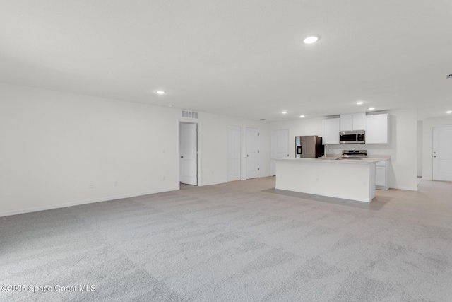 unfurnished living room featuring light carpet