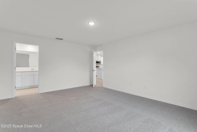 spare room featuring light colored carpet