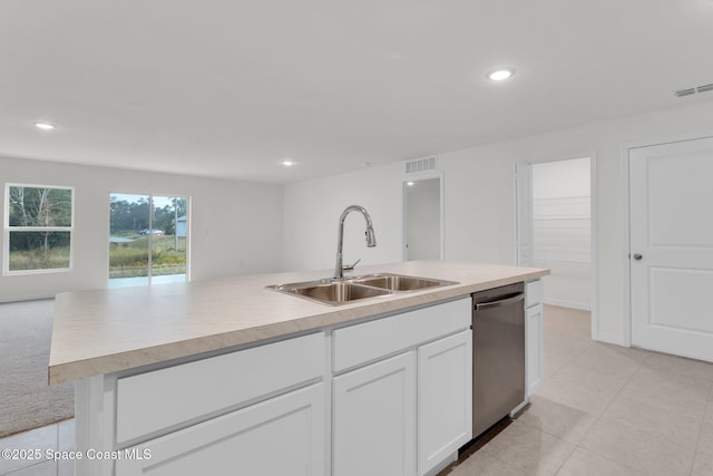 kitchen with white cabinets, light colored carpet, sink, dishwasher, and an island with sink