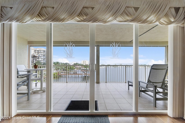 unfurnished sunroom with a wealth of natural light and a water view