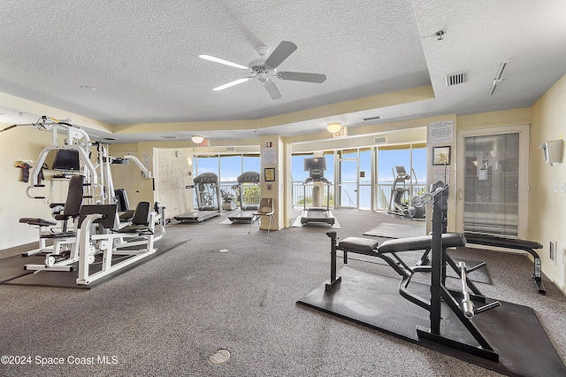 workout area featuring ceiling fan and a textured ceiling