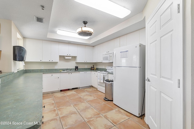 kitchen with a textured ceiling, white appliances, a raised ceiling, sink, and white cabinets