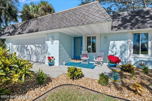 back of house with covered porch and a garage