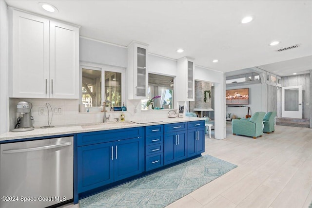 kitchen featuring decorative backsplash, white cabinets, sink, blue cabinetry, and dishwasher