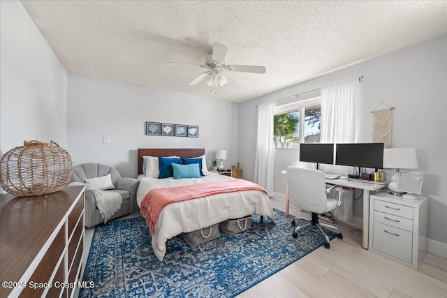 bedroom featuring ceiling fan, light hardwood / wood-style floors, and a textured ceiling