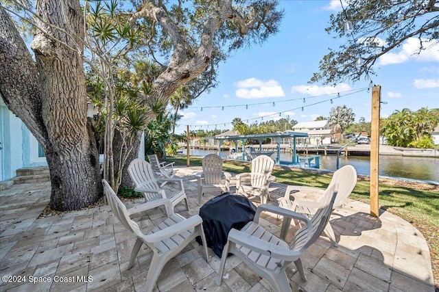 view of patio with a dock and a water view