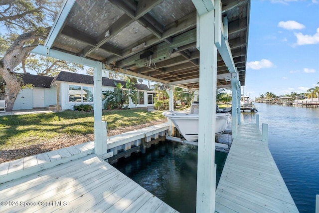 view of dock with a yard and a water view