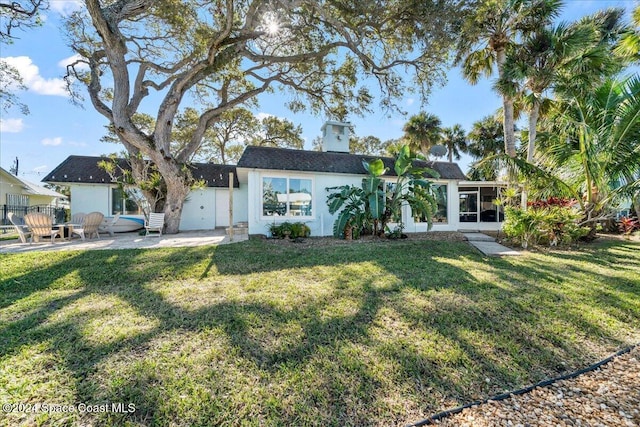 view of front of home featuring a sunroom, a patio, and a front yard