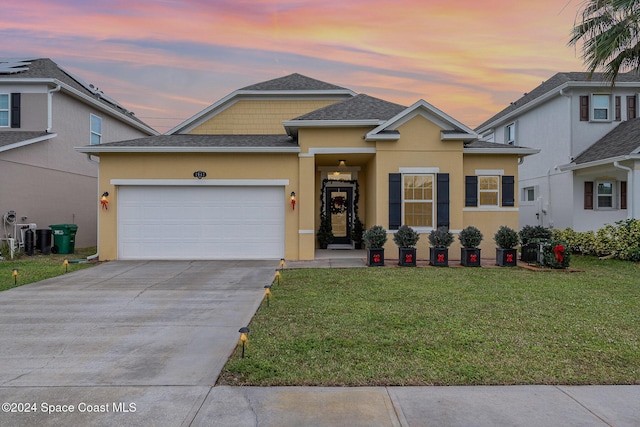 view of front of home with a garage and a lawn