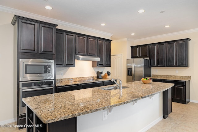 kitchen featuring a kitchen bar, appliances with stainless steel finishes, crown molding, sink, and an island with sink