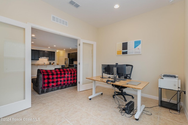 office with light tile patterned floors and french doors