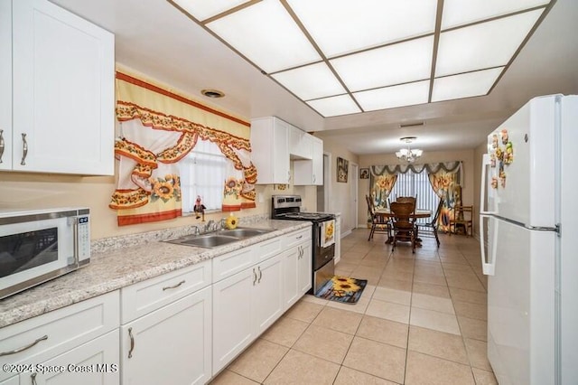 kitchen with sink, white cabinets, white refrigerator, stainless steel range with electric stovetop, and light tile patterned floors