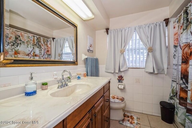 bathroom featuring tile patterned floors, vanity, tile walls, and toilet