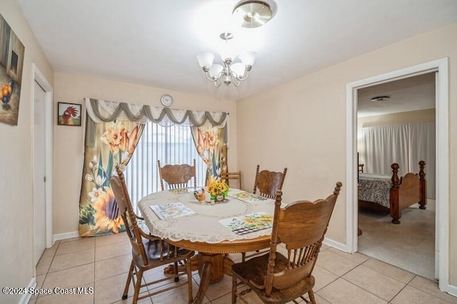 dining space featuring light tile patterned flooring and an inviting chandelier