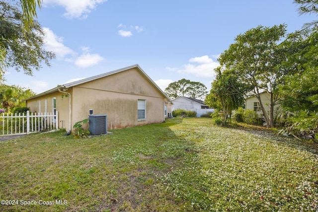 exterior space with a lawn and central AC unit