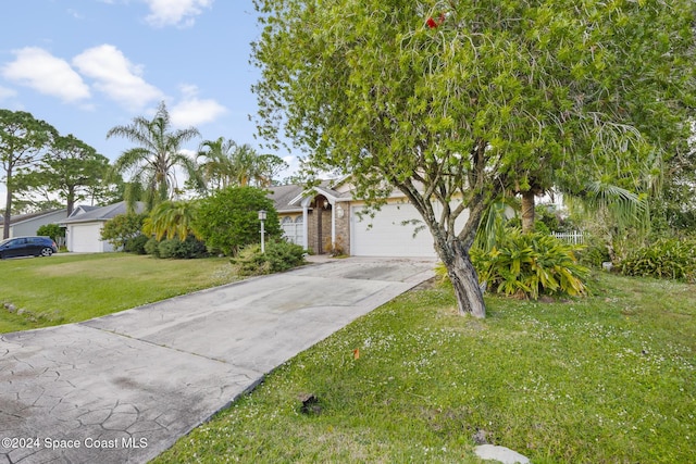 view of property hidden behind natural elements featuring a garage and a front yard