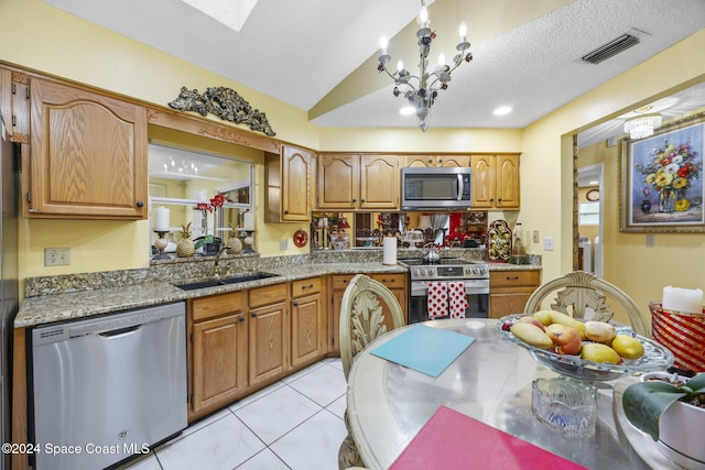 kitchen with lofted ceiling, sink, light tile patterned floors, a textured ceiling, and stainless steel appliances