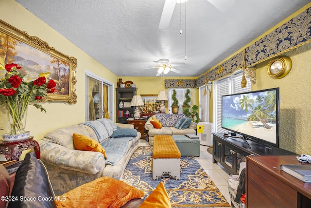 living room featuring ceiling fan, light tile patterned floors, and a textured ceiling