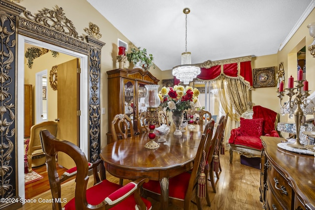 dining room with hardwood / wood-style flooring, lofted ceiling, and an inviting chandelier