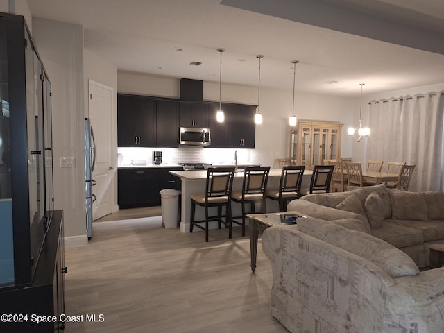 living room with a chandelier and light hardwood / wood-style flooring