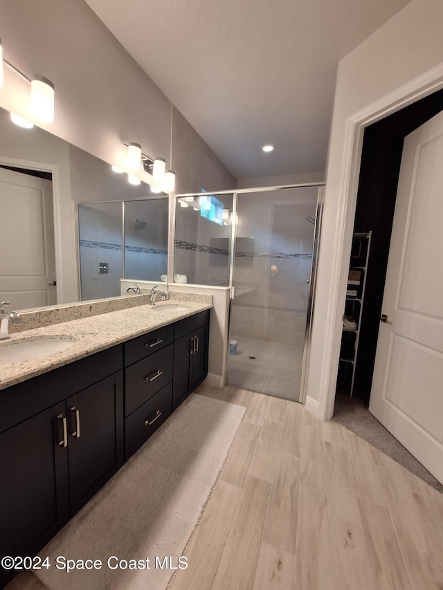 bathroom featuring vanity and a shower with door