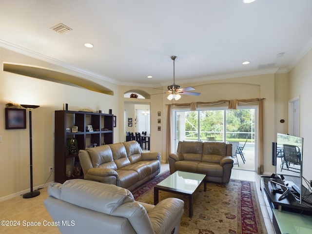 tiled living room with ceiling fan and crown molding