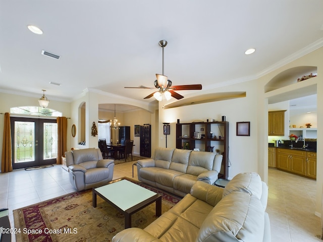 living room featuring french doors, light tile patterned flooring, ornamental molding, and sink