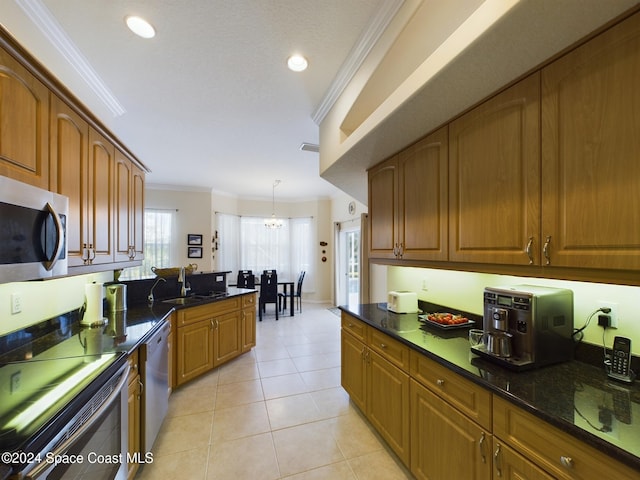 kitchen with sink, an inviting chandelier, dark stone counters, light tile patterned floors, and ornamental molding