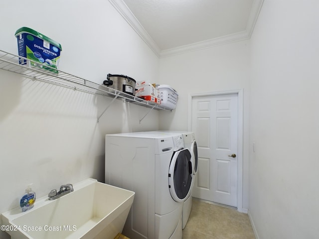 laundry area with washing machine and clothes dryer, sink, light tile patterned floors, and ornamental molding