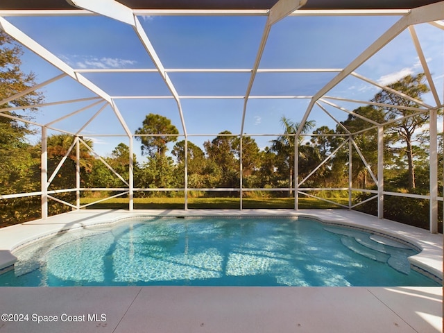 view of pool with glass enclosure