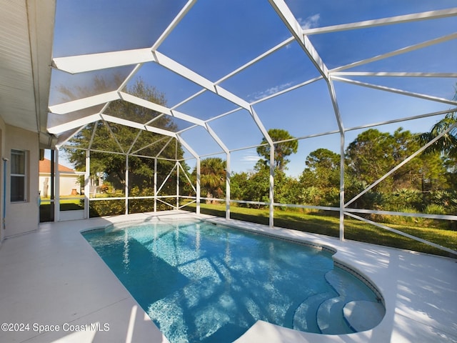 view of swimming pool featuring a patio and glass enclosure