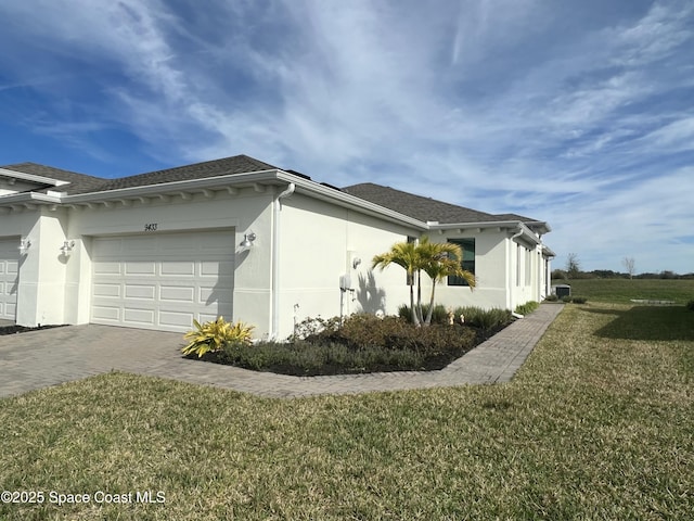 view of side of home featuring a garage and a lawn