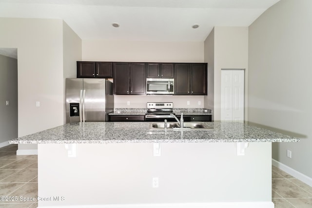 kitchen featuring appliances with stainless steel finishes, a kitchen island with sink, sink, and light tile patterned floors