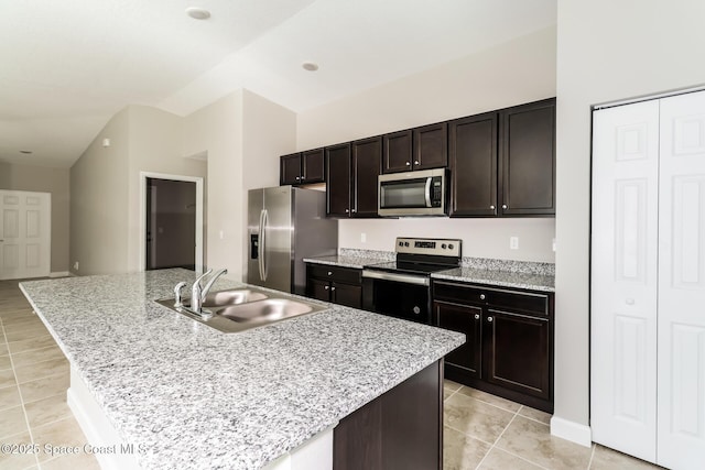 kitchen featuring a kitchen island with sink, sink, stainless steel appliances, and dark brown cabinetry