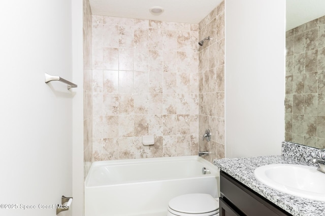 full bathroom featuring tiled shower / bath, vanity, and toilet